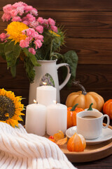 Autumn romantic evening, ripe pumpkins by candlelight. Bouquet of yellow autumn flowers