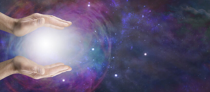 Working with Cosmic healing orb energy - male holding an energy ball between his open parallel hands against a vast expanse of deep space with copy space for spiritual message

