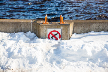 A no jump in the water sign, but the bottom of it is blocked by snow. No jump in the snow.