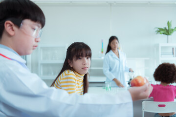 Obraz premium In the science classroom, an Asian child scientist experimenting with scientific formulas with chemicals