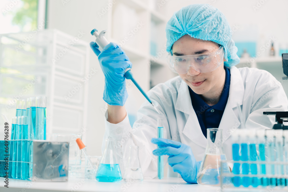 Wall mural scientist analyzing and dropping a sample into a glassware, medicine science experiments containing 