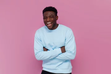 Tuinposter cheerful african american man in blue sweater laughing on pink isolated background © Богдан Маліцький