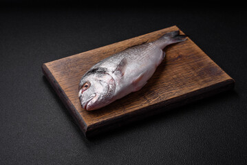 Fresh raw dorada fish with salt, spices and herbs