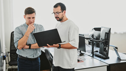 Portrait of two professional male programmers working on computer in diverse offices. Modern IT technologies, development of artificial intelligence, programs, applications and video games concept