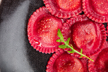 beetroot ravioli beet red pasta in the plate ready to eat appetizer meal food snack on the table...