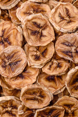 Round slices of sweet banana on a dark concrete background