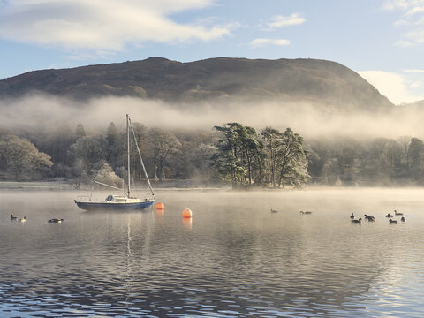 Boat on misty Coniston in winter time in the english lake district