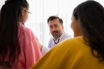 Doctor with stethoscope examining kid patient in hospital. Healthcare and medical concept.