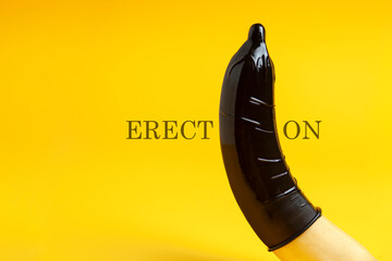 condom dressed on a banana on a yellow background, erection concept, safe sex concept, sexual male...