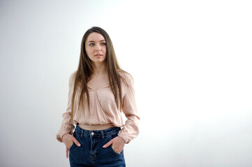 Close-up young slender woman holding her hands at waist of her jeans on white studio background. High quality photo