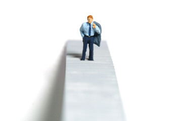 Miniature tiny people toy figure photography. Business concept illustration. A businessman walking...