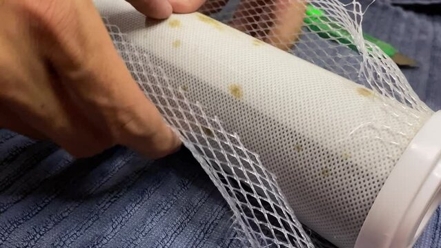 Hands cut open dirty mold water purifier filter activated carbon block close up view. Health and hygienc concept