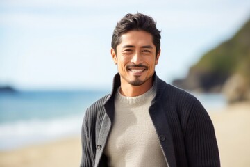 Smiling young man by the sea, casual attire and facial hair