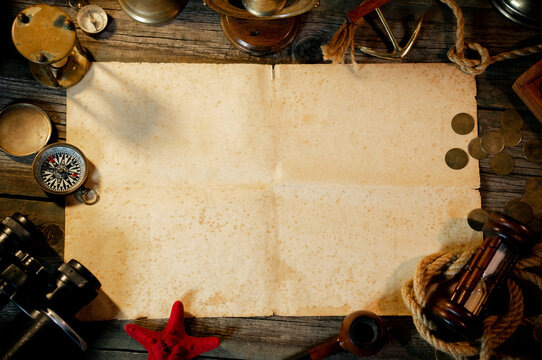Treasure island concept on a wooden table background. Sheet of paper for text or map