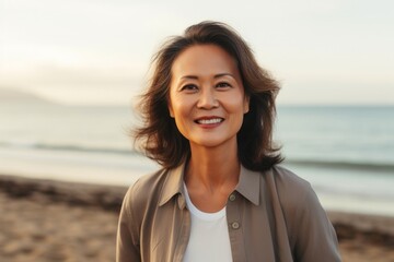 Cheerful woman with casual clothing enjoying a beach getaway, smiling and gazing at the camera