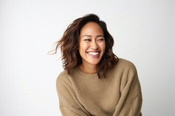 Fototapeta premium Attractive woman with curly brown hair smiling at camera in studio