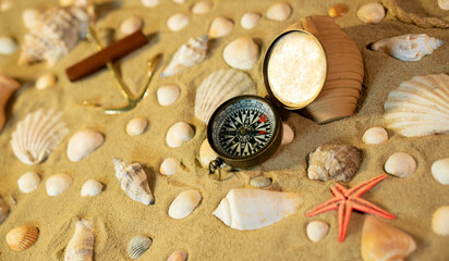 Fototapeta na wymiar Vintage comass on sand among shells and stones