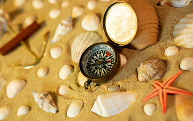 Vintage comass on sand among shells and stones