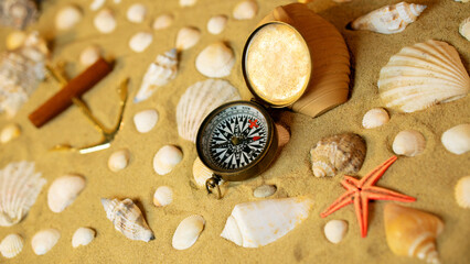 Vintage comass on sand among shells and stones.	