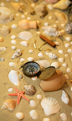 Vintage comass on sand among shells and stones.