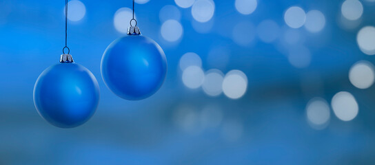 Blauer unscharfer Weihnachtshintergrund mit Weihanchtskugeln