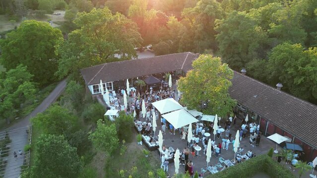 In dieser Aufnahme feiern unten die Partyg&auml;ste in einer Veranstaltungsst&auml;tte im Killesbergpark in Stuttgart, w&auml;hrend die Drohne aufsteigt, um die festliche Szene und die Umgebung des Parks einzufangen
