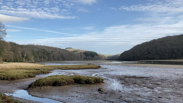 Panning shot of the beautiful Erme River Estuary at low tide in early morning with birds gathering on the flats - Nr Holbeton, Devon, UK