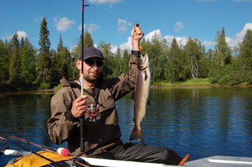 Fisherman caught a big salmon in the northern river.