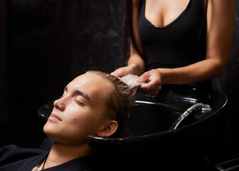 Hairstylist Hairdresser Washing Customer Hair - Young Man Relaxing In Hairdressing Beauty Salon.