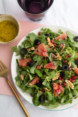 Rocket (arugula) and lamb's lettuce salad with grapefruit, pomegranate seeds, black olives, capers, walnuts, and mustard vinaigrette dressing