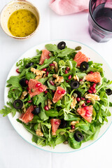 Rocket (arugula) and lamb's lettuce salad with grapefruit, pomegranate seeds, black olives, capers, walnuts, and mustard vinaigrette dressing