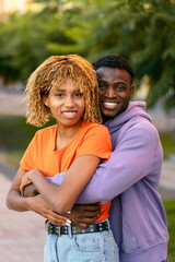 Fototapeta premium Portrait of beautiful happy couple friends hugging looking at camera standing together in park. Relationship, date concept 