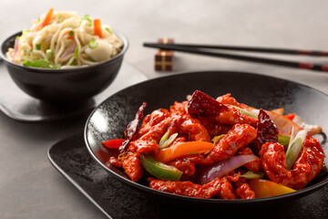 Dragon chicken include bell pepper, red chilli and carrot and chowmein with chopsticks served in dish isolated on background top view of chinese food