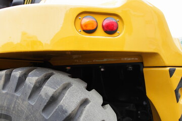 Big wheel and tail lights on board of yellow heavy forklift truck © Ilya