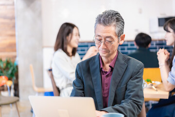 カフェで仕事をする中年男性