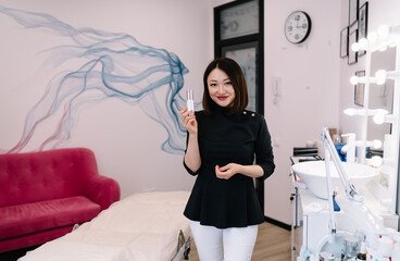 Smiling cosmetician showing beauty product in salon