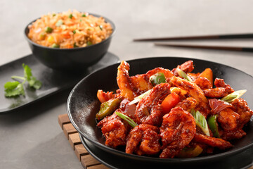 szechuan prawn include bell pepper, tomato, spring onion with schezwan fried rice and chopsticks served in bowl top view of chinese food
