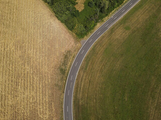 Drone view of a curved road between fields in the landscape