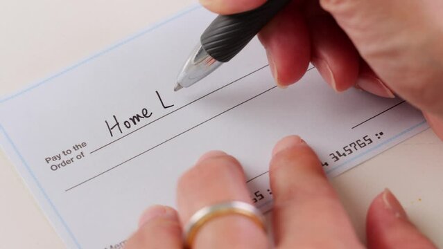 Close-up shot of a check being written for home loan.