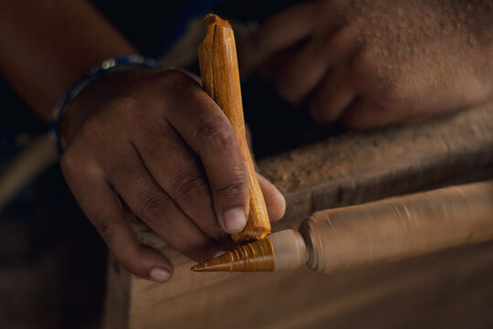 Cropped hands of women carving wood