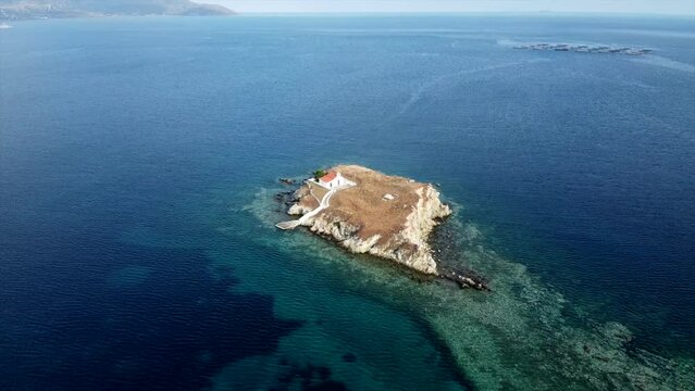 Small uninhabited island with a church aerial cinematic drone footage Greece
