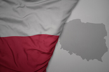 big waving national colorful flag and map of poland on the gray background.