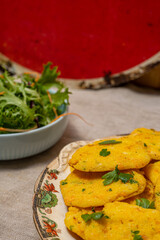 Cornmeal Fritters garnished with fresh parsley, served alongside a crisp lettuce and carrot salad. A rustic, vegan delight.