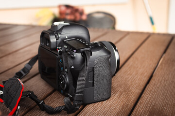 Camera Canon on wooden table. Photography hobby. Modern media technology. Digital optical camera. Professional body cam. Entertainment concept. 