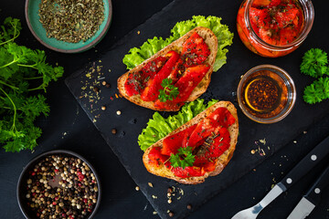Tasty bruschetta with roast bell pepper and garlic on wooden table

