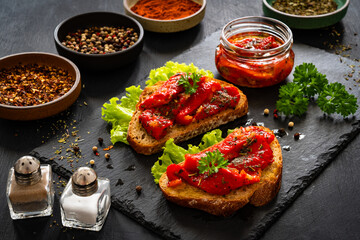 Tasty bruschetta with roast bell pepper and garlic on wooden table

