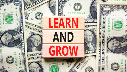 Learn and grow symbol. Concept word Learn And Grow on beautiful wooden block. Dollar bills....