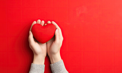 Male hands delicately holding a red heart. Valentine's Day concept.