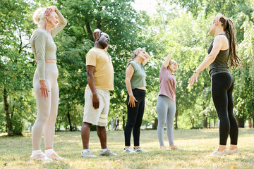 Senior people standing in a row and training outdoors together with coach