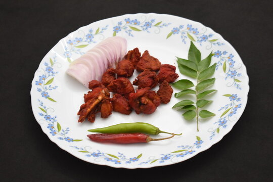 tasty crispy chicken 65 fry white plated background onion red green chilli